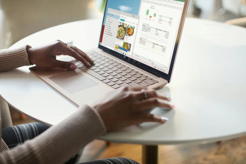 a woman is sitting at a table with her lap top open