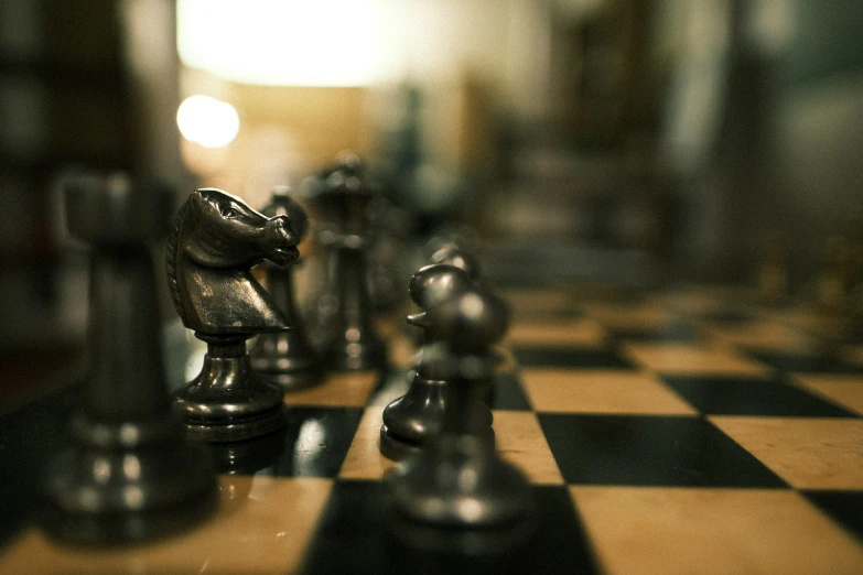 an artistic po of metal chess pieces on a black and white checkered board