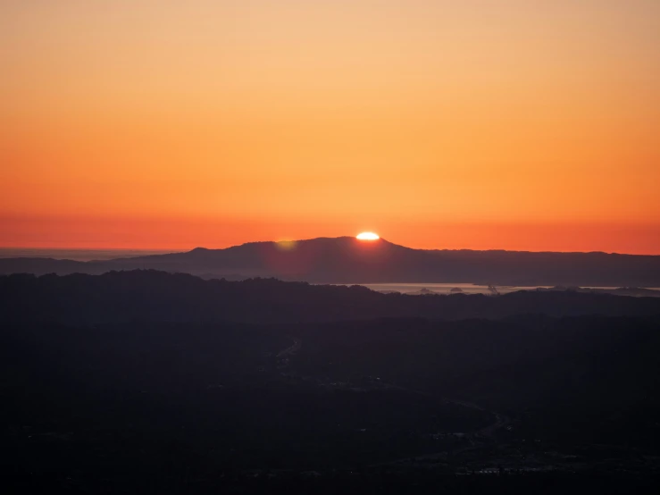 the sun rises over the mountains at dawn