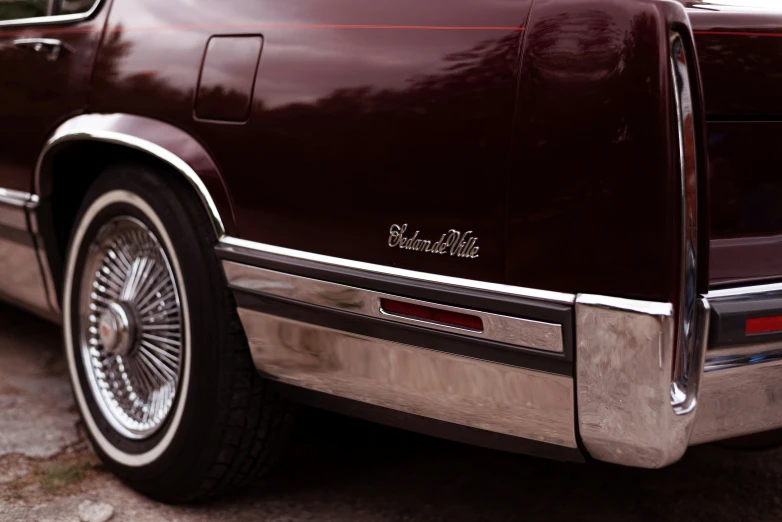 a maroon station wagon sits on the pavement