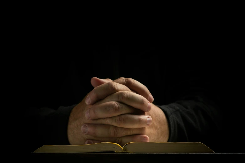 a man holding his hands together, with his arms folded