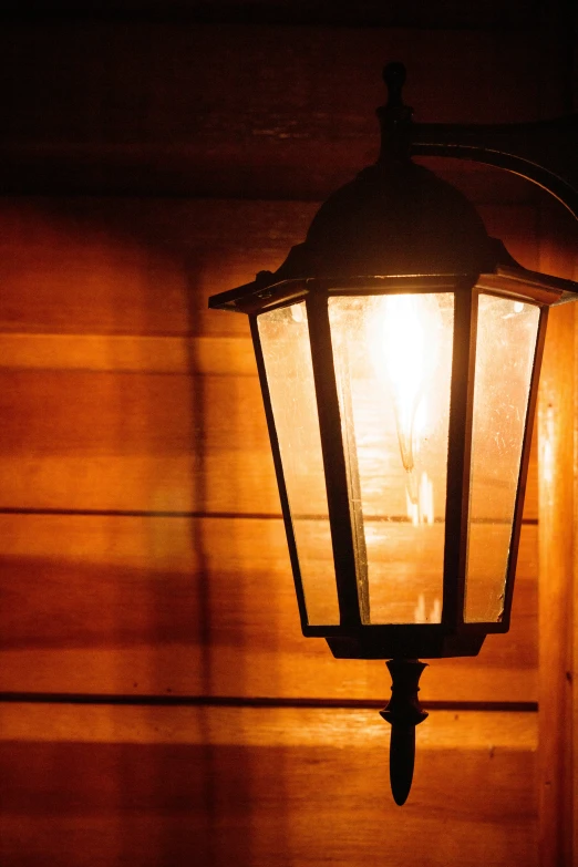 an old - fashioned lamp shines brightly on a building at night
