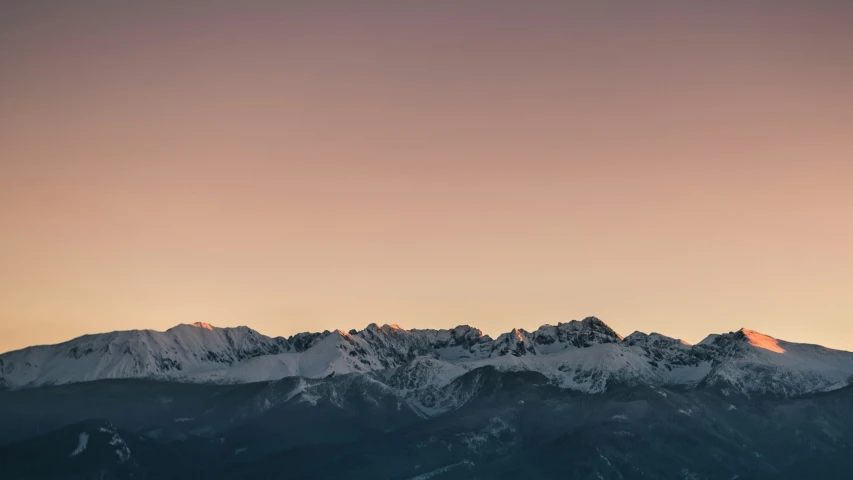 snow capped mountains at sunrise as the sun sets