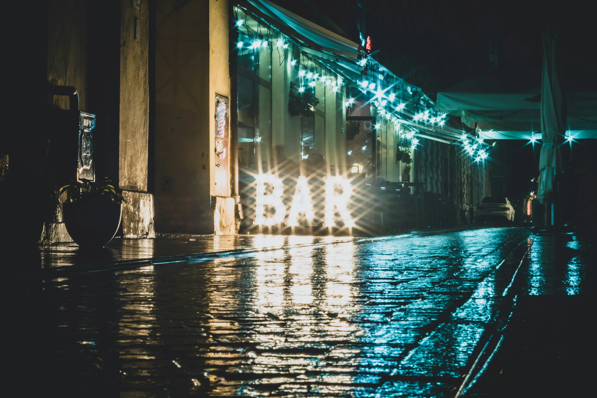 a sign is lit up with the lights in the rain