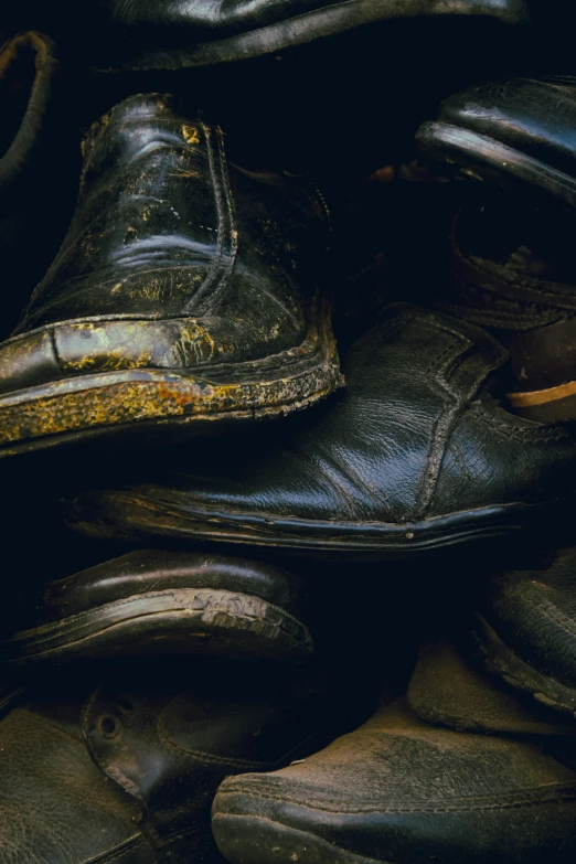 a collection of old worn out shoes and boots