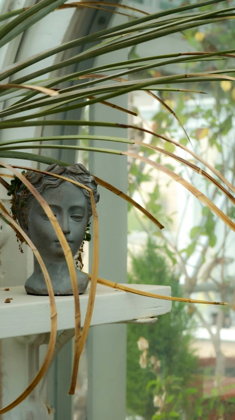 a statue of a buddha head is on a shelf