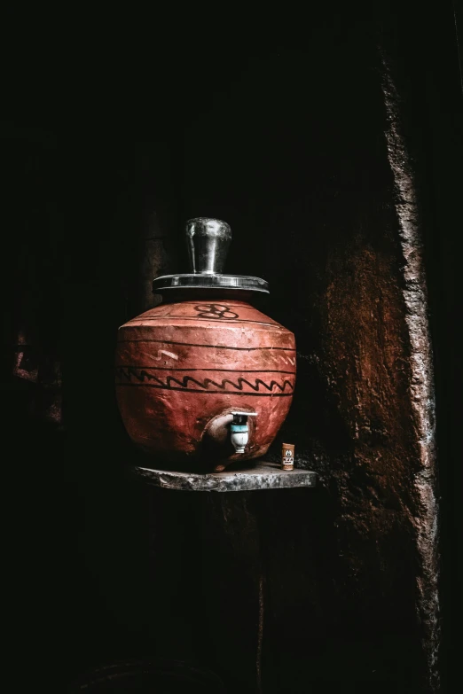 a vase with writing on the bottom and a lid is sitting on a stand