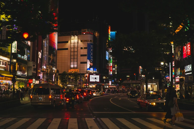 people and vehicles are travelling down the street in a busy city