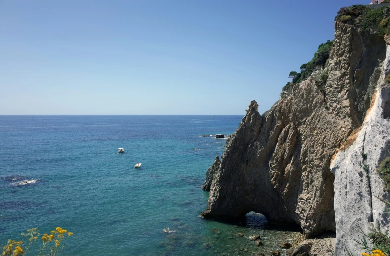 this is a natural rocky coast with several boats