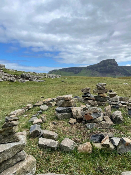 rock piles are arranged in a field, facing away from the camera