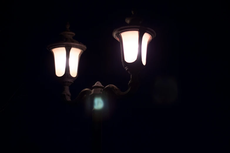 two old fashioned street lamps at night time