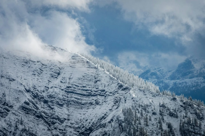 a scenic view of snow covered mountains with clouds in the sky