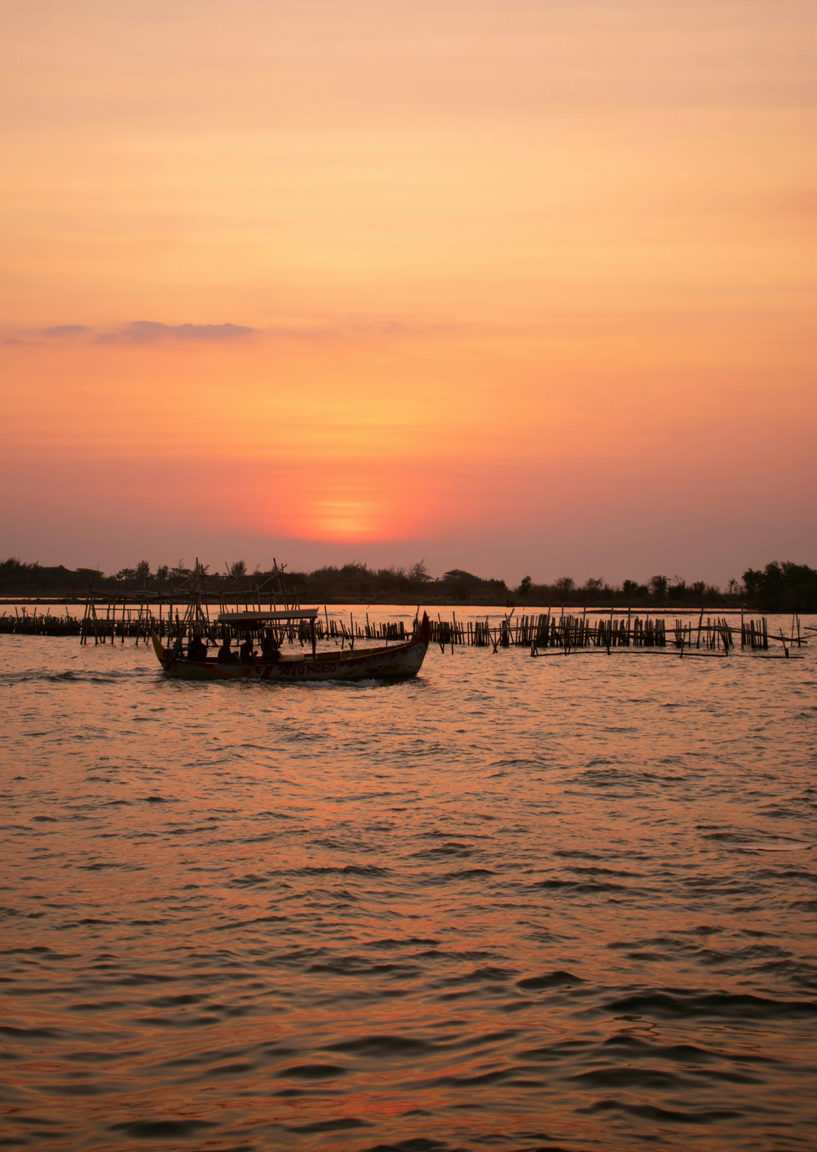 a boat floating on top of a body of water at dusk