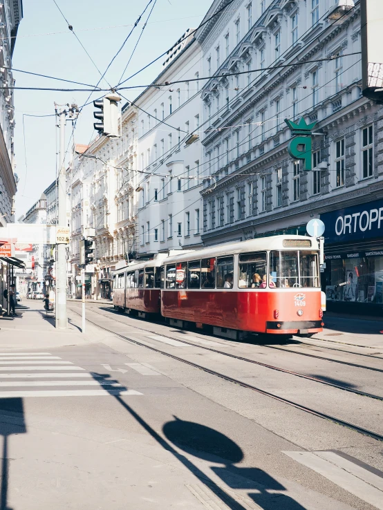 an old fashioned trolley on the street between large buildings