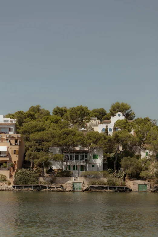 a home and beach along the waterfront next to a city