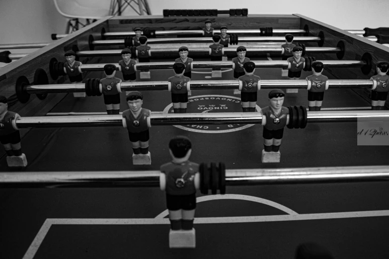 a foo - ball table with people wearing uniforms on it