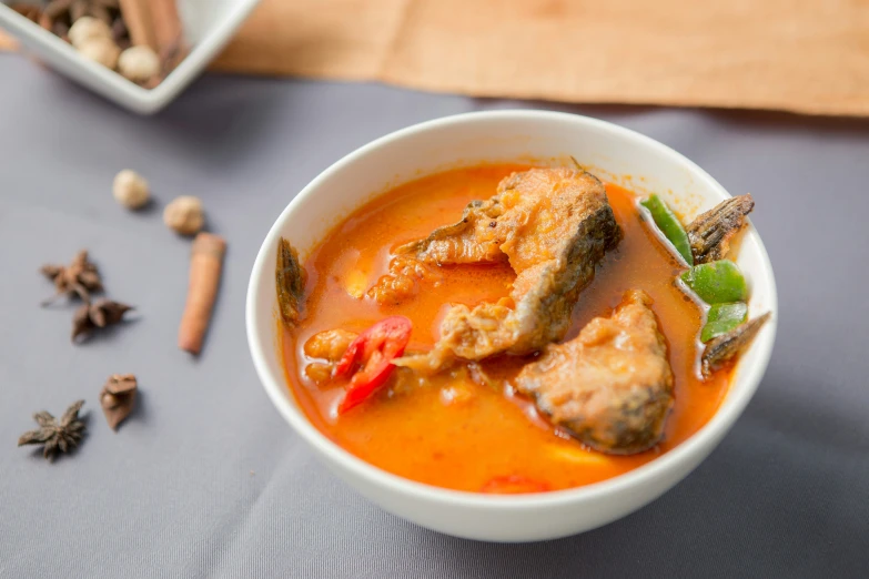 a bowl of soup with seafood and spices