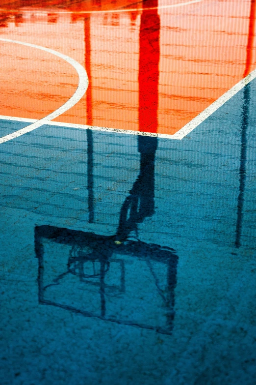 a shadow of a person is seen on a tennis court