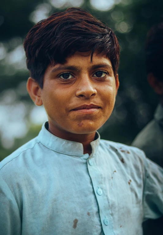 a boy with brown hair wearing blue shirt
