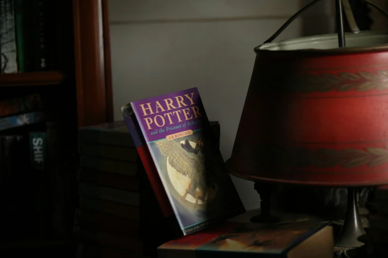 a lamp and harry potter book on a table