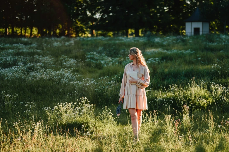 a woman in a short dress walks through an open field