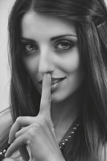 a beautiful young lady with a finger in her nose