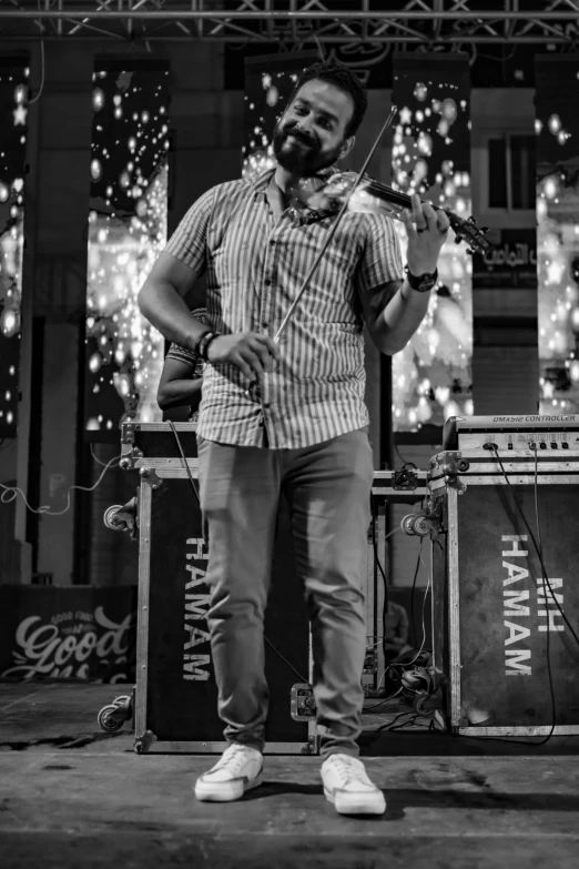 a man playing an acoustic instrument in front of microphones