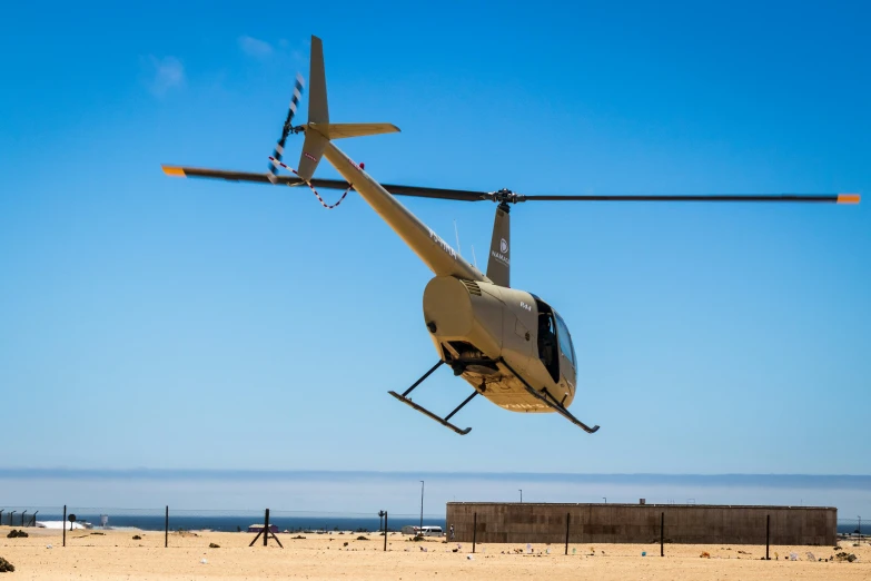 a helicopter flying low over a sandy beach