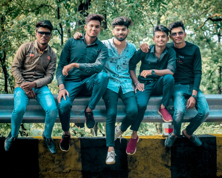 a group of young men sitting next to each other on a metal bench