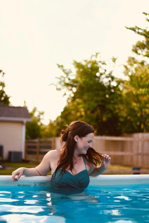 a girl wearing a swim suit leaning up in a pool