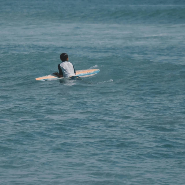 a man riding on top of a surfboard on top of the ocean