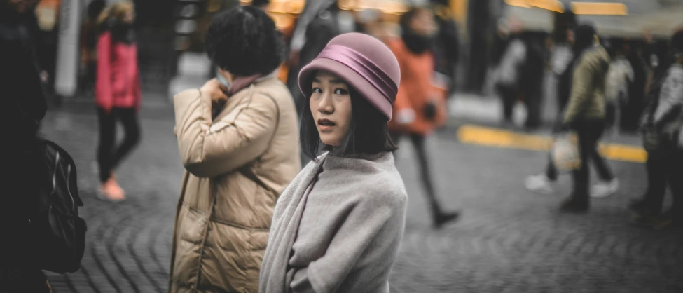 a young woman is covering her ears while standing in the street