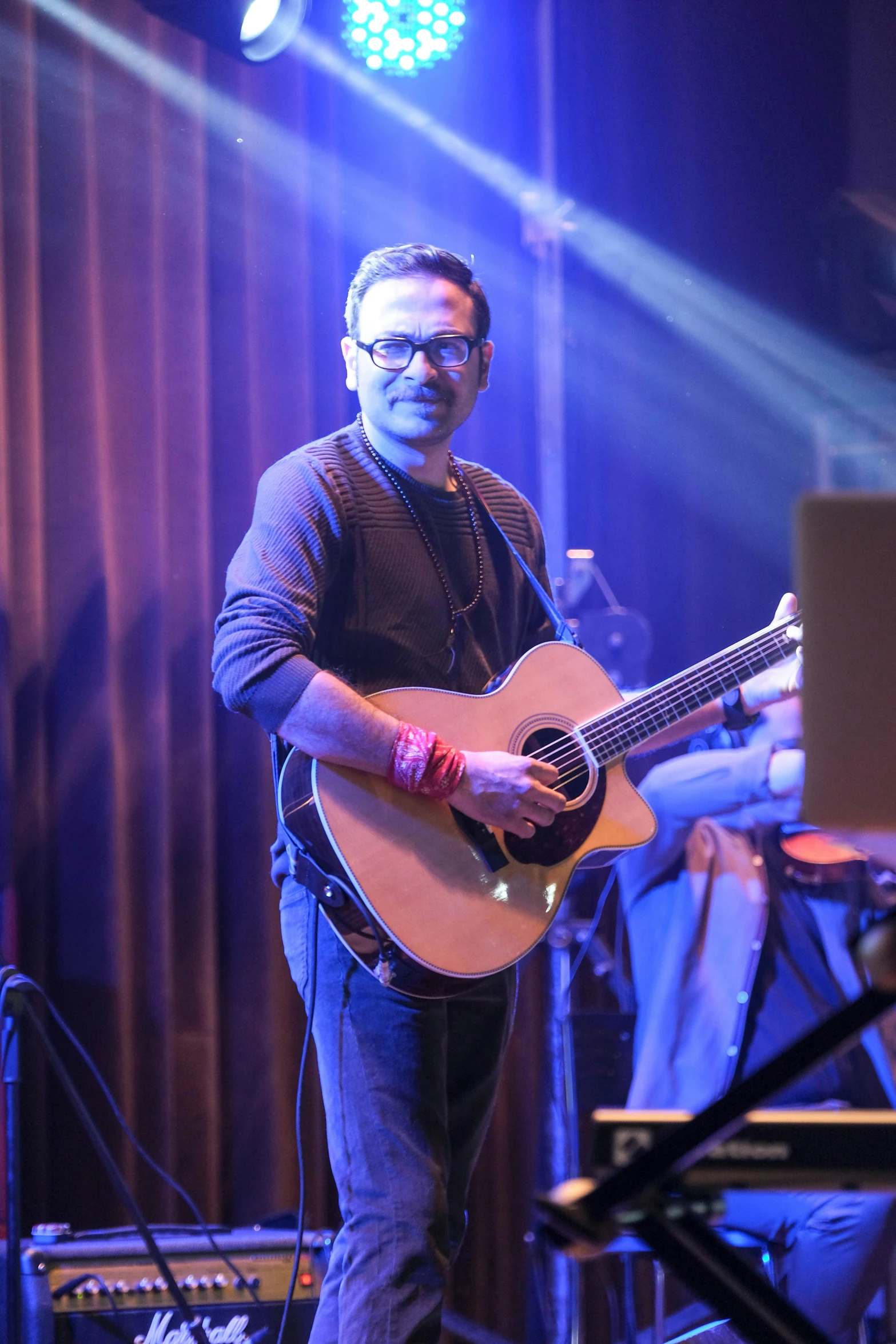 a man is playing the guitar on stage