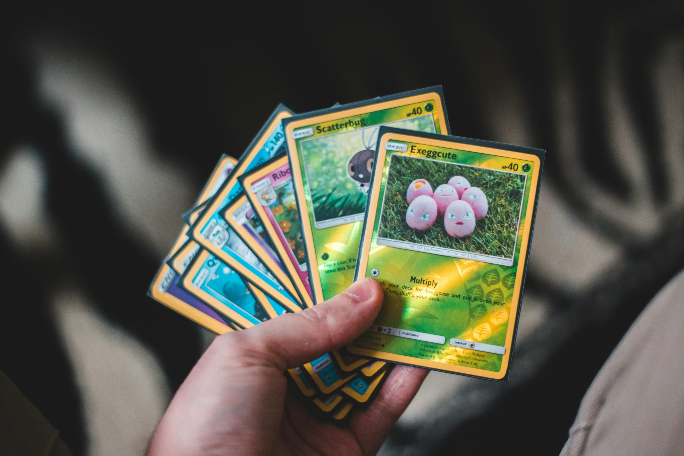 a man holds up four cards that show their pokemon cards