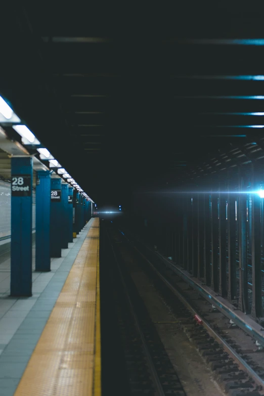 a empty train station with lights on in the dark