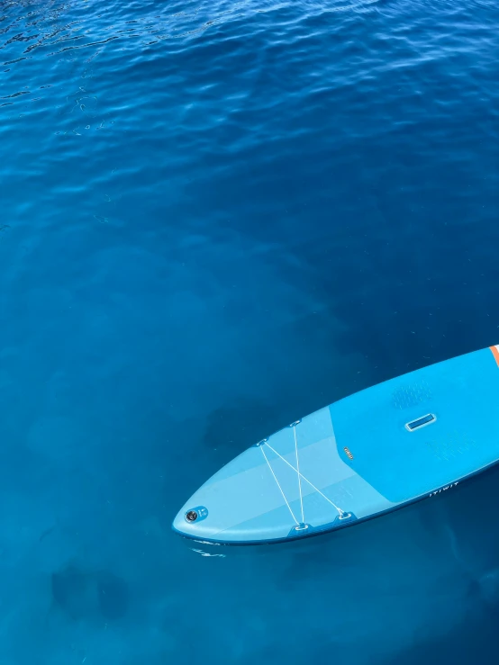 the surfboard is floating in blue water near another one