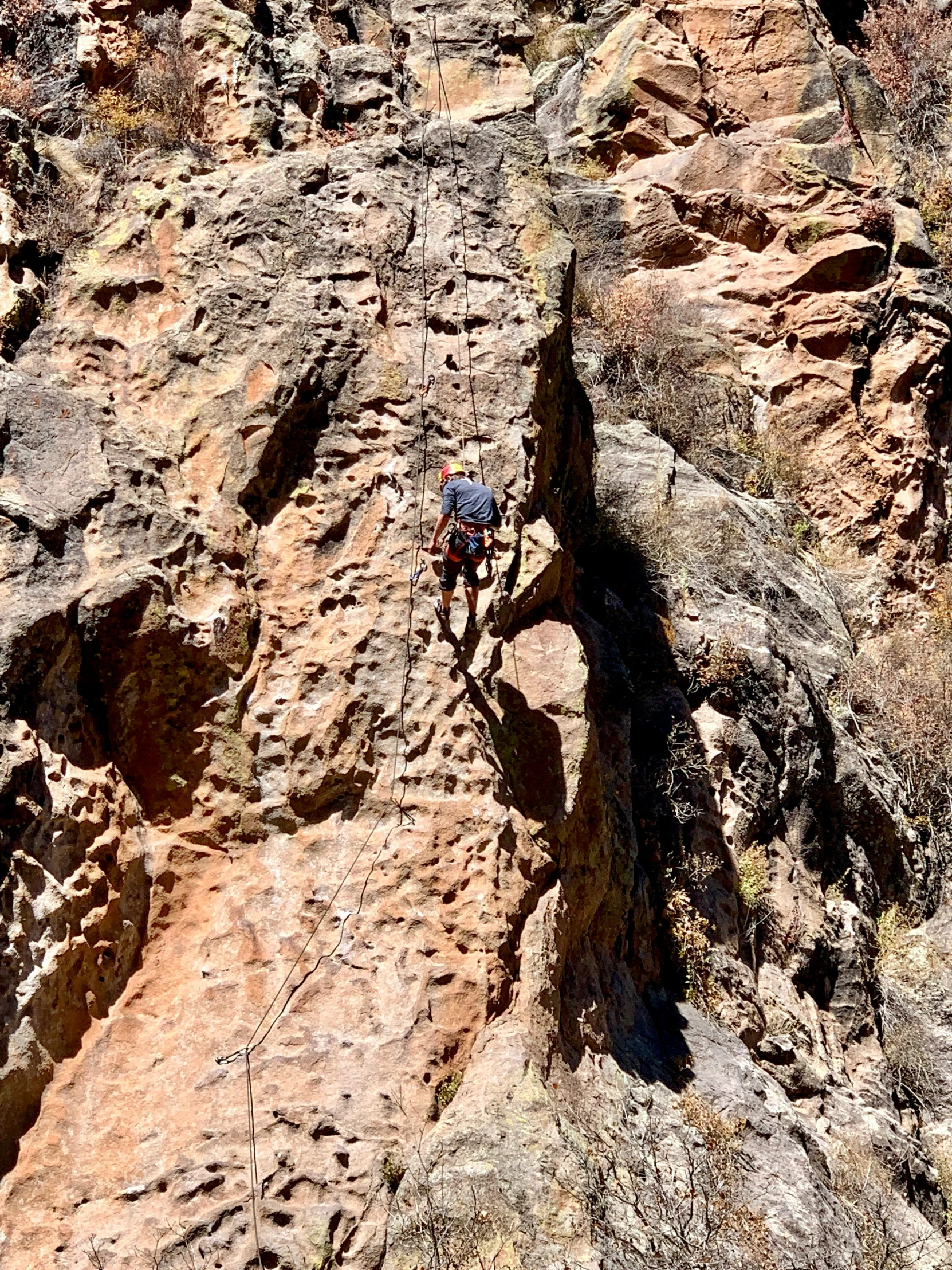 the person is climbing up the side of a mountain