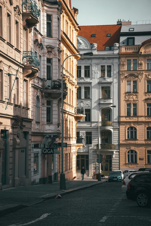 the cars are parked on the street by the buildings