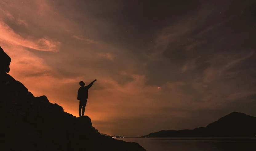 a person on top of a cliff overlooking the ocean