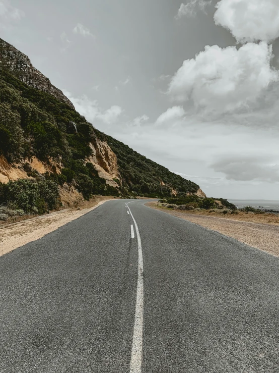 the black and white image is of an empty road