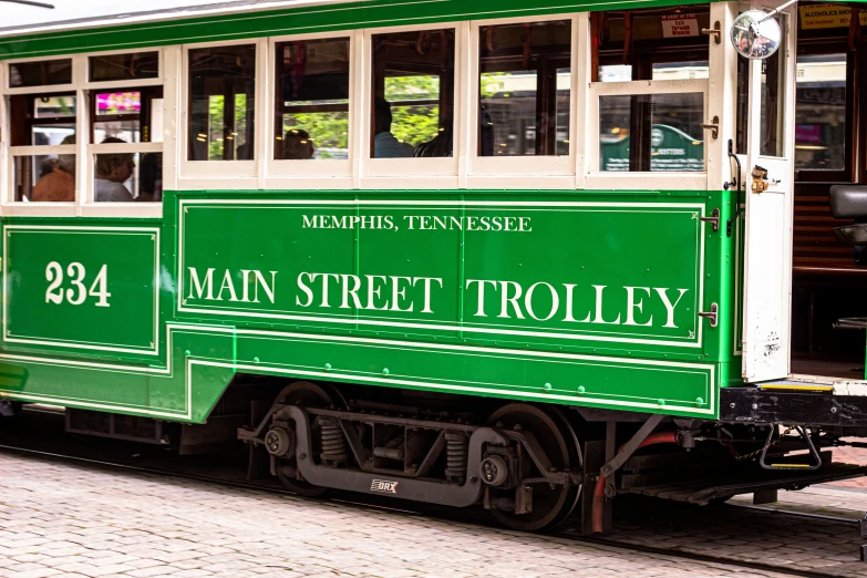 a man stands on the street side beside the train