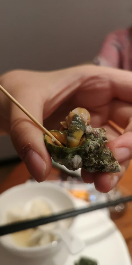 a person holding food on a fork over some rice