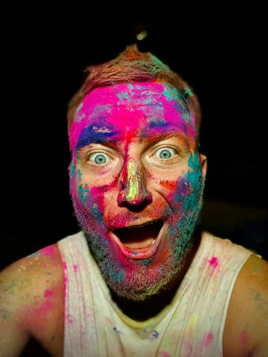 the man is dressed as a troll while painting all over his face