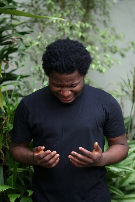 a man in a black shirt is holding his hands out