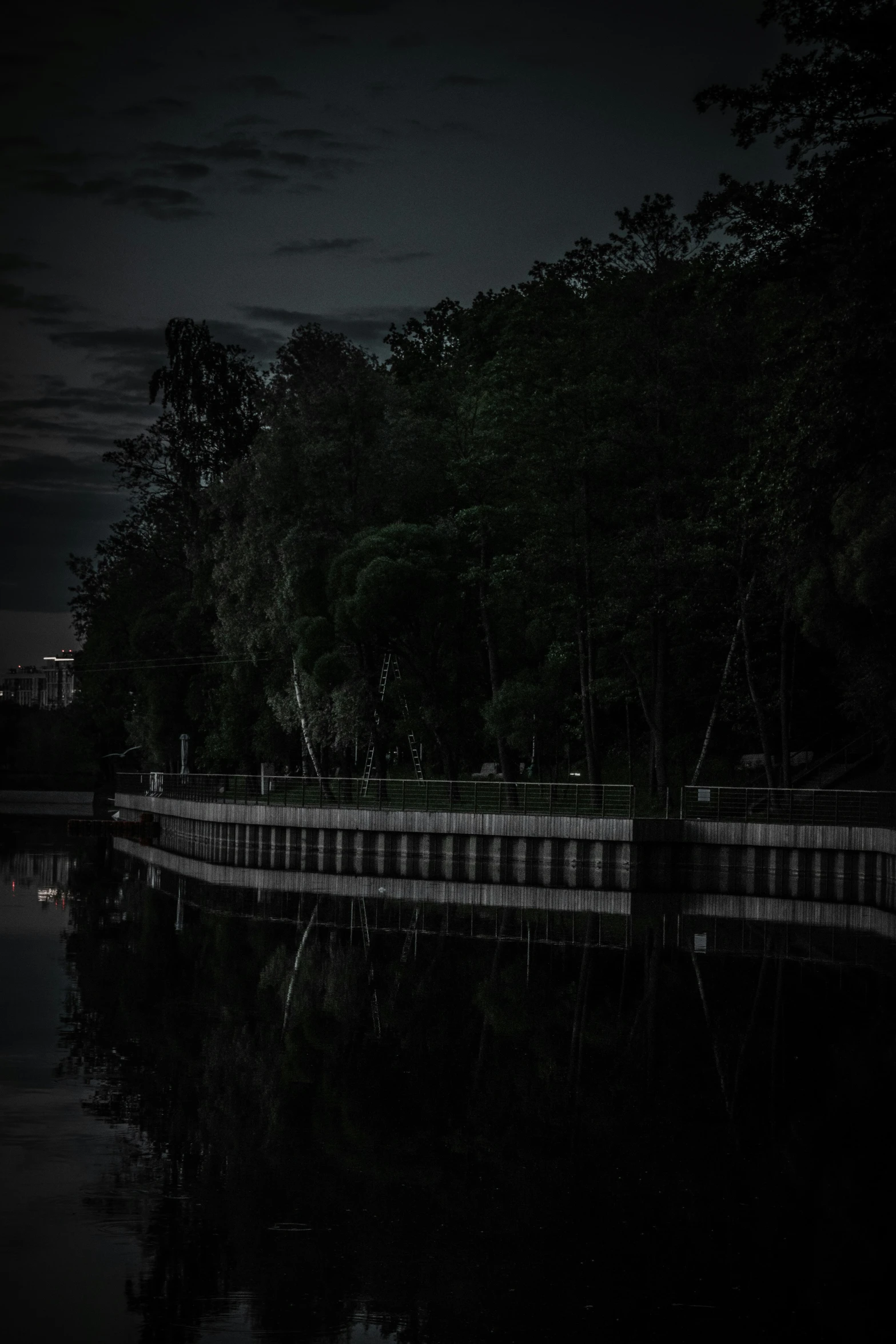 a dark river and benches are lit up