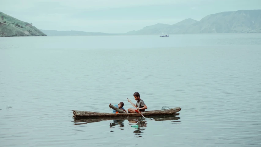 two people sitting in a small canoe on a large body of water