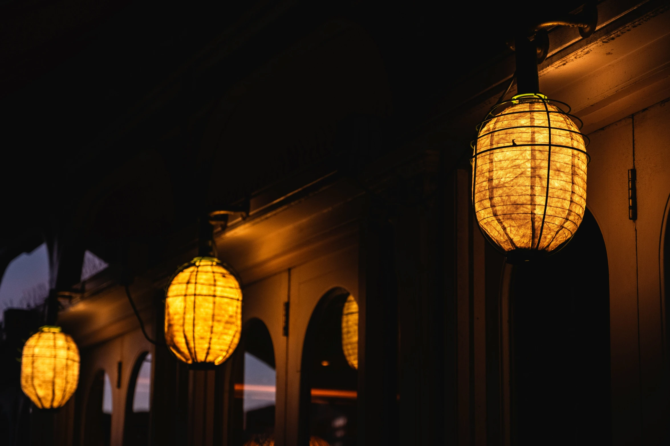 a lit lamp hanging over some doorways in the dark