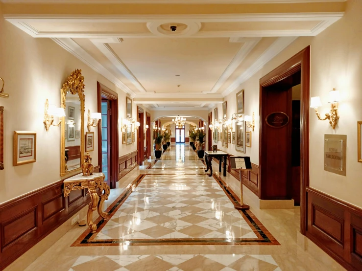 a building hallway with marble floor and gold trim