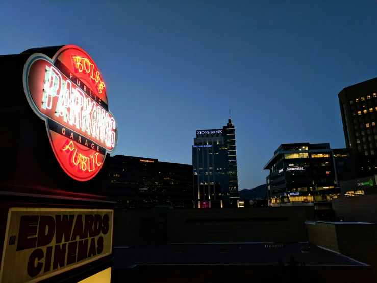 a city skyline with skyscrs and the neon sign