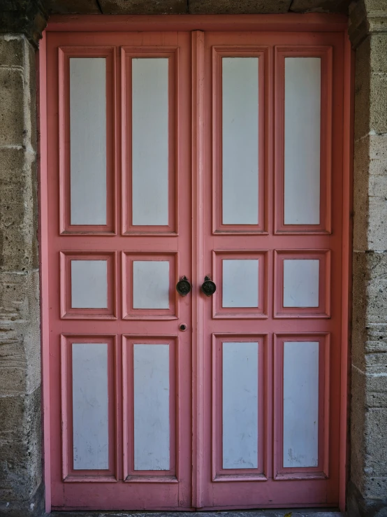 a red and white front door is next to brick wall